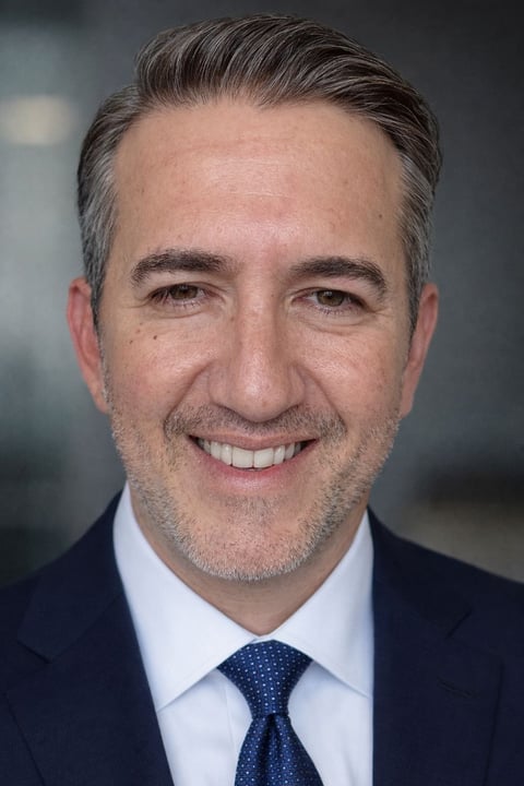 Headshot of Arturo Alex Rankin in a dark suit with salt-and-pepper hair, smiling at the camera